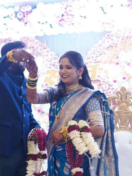 A candid moment from a reception celebration. The bride's makeup is elegant and polished, perfect for greeting guests and enjoying the festivities.