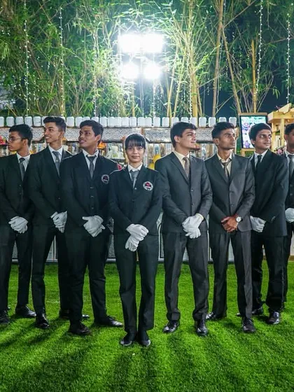 Our team in modern black suits, ready for service at an outdoor event. This showcases our readiness for any type of venue or occasion.
