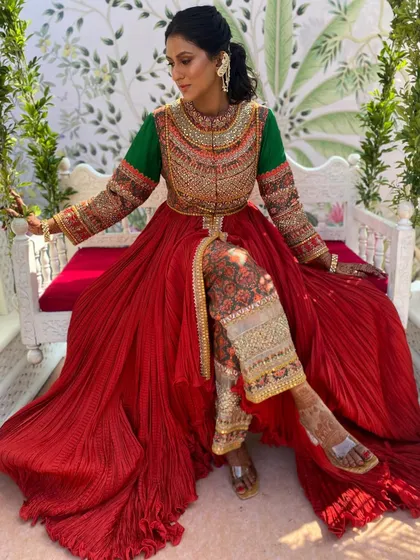 A full shot of the client wearing a textured ponytail with a statement ear-to-hair accessory, perfect for her vibrant Mehendi outfit.