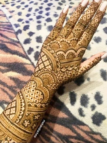 A close up of an intricate back-hand design. The fine lines and detailed patterns showcase the precision and skill required for this art form.