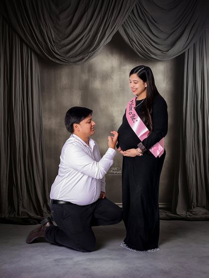 A classic "Mom to Be" sash adds a fun and celebratory element to this studio couple's portrait. It's a lovely prop for capturing the excitement.