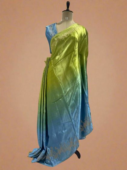 A shaded satin crepe saree with a flamingo border, blending from green to blue.
