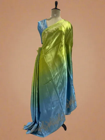 A shaded satin crepe saree with a flamingo border, blending from green to blue.