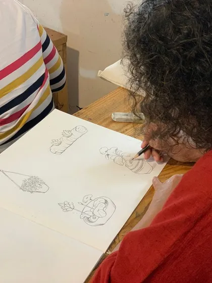 A student sketches out different compositions in her notebook. Our classroom is a space for experimentation and practice, where ideas begin to take shape.