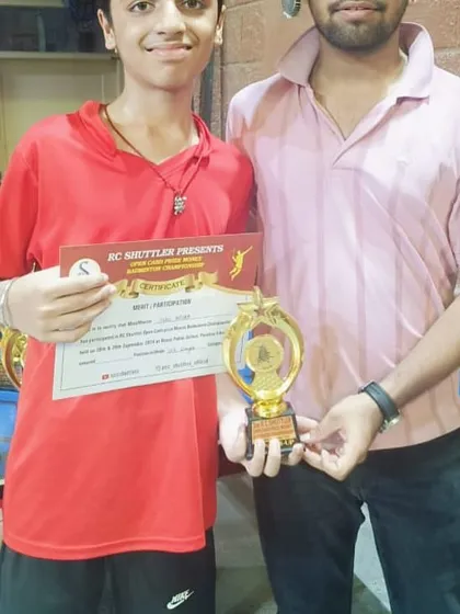 A student poses with his trophy and certificate alongside one of our coaches. This highlights the strong player-coach partnership we build to guide players through their competitive journey.