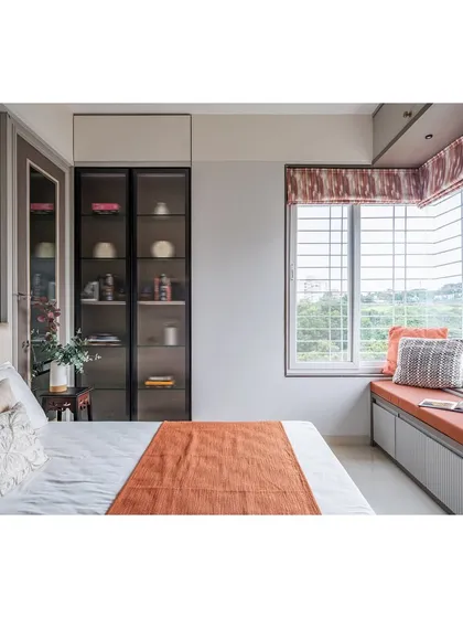 A closer look at the bed and window area. The glass-fronted display cabinet adds a touch of elegance and provides a space for personal treasures.