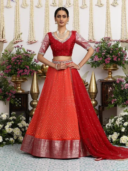 Another view of the orange and red lehenga, showcasing its vibrant colors and rich textures.