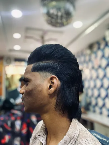 The modern mullet is one of my specialties. I keep it fresh with a seamless fade on the sides, a styled pompadour on top, and a clean, flowing look at the back.