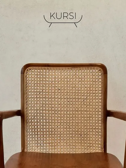 The front view of the 'Tara' armchair, showcasing the clean lines of the teak frame and the perfectly tensioned rattan backrest.