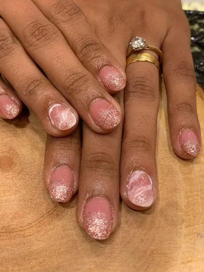 The perfect nails for a bride-to-be. This elegant set combines a soft pink glitter ombre with a beautiful white marble accent nail for a sophisticated bridal look.