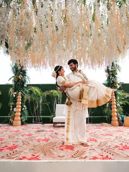 A joyful lift on the mandap. This shot is full of happiness and celebration, capturing a beautiful moment from a South Indian wedding.