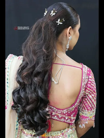 Lost in a sea of soft waves and dreamy textures. This romantic half-up hairstyle is adorned with delicate butterfly clips, perfect for a special occasion.