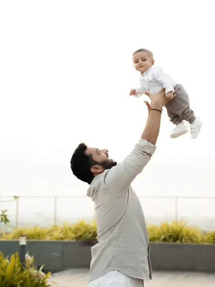 A joyful moment between a father and his baby, lifting him up into the air. I focus on capturing these dynamic, emotional shots during family sessions.