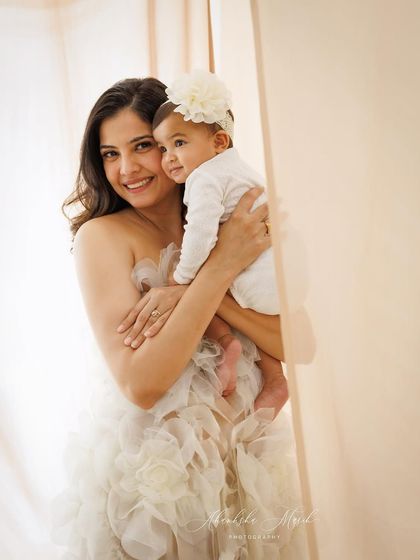 A tender moment between mother and child. The soft, neutral tones and the mother's gentle embrace create a feeling of warmth, love, and security.