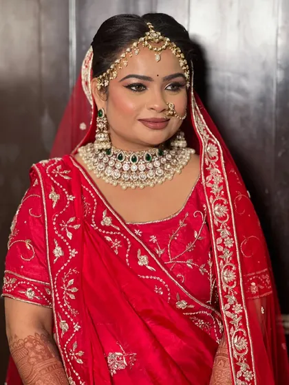 The bride looking to the side, showcasing her elegant hair updo and the fit of her blouse.