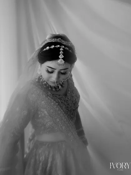 A soft and dreamy black and white portrait of the bride. The focus on her gentle expression and the delicate details of her attire creates a timeless and romantic feel.