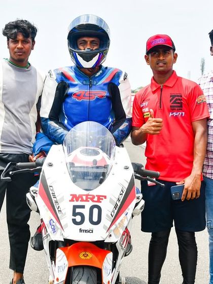 The team stands with Rohith on the grid, a visual representation of our "never solo" support system. We are with our riders every step of the way.