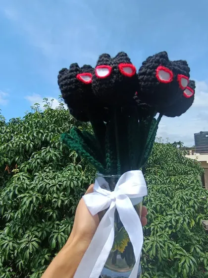 A bouquet of the black Spiderman-themed tulips, held up against the sky.