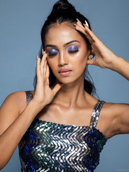 A beauty portrait with the model's eyes closed, showcasing the vibrant purple and blue eyeshadow. This is a great way to feature detailed makeup work.