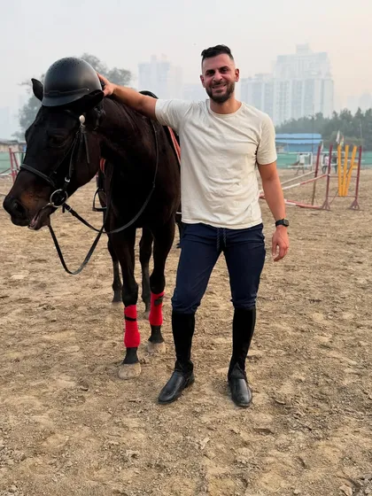 Our horses are friendly and comfortable around people, making them great partners for solo portraits. This client shares a relaxed moment with one of our dark-coated horses.