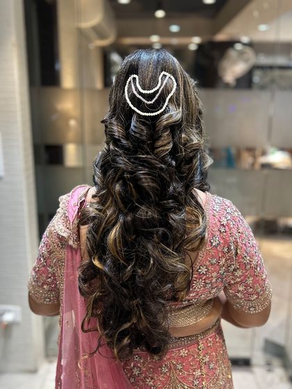 Another angle of the curly open hairstyle, showing the texture and shine.