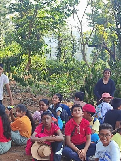 A group of campers takes a well-deserved rest during their trek, enjoying the shade and scenery.