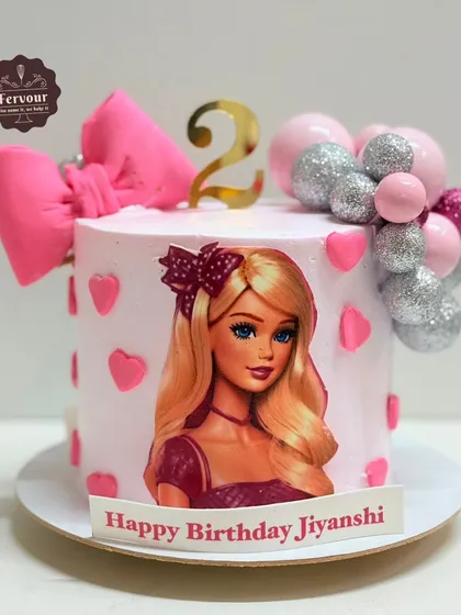 Another take on the Barbie theme, this cake features a Barbie photo, a big pink bow, and a cascade of pink and silver glitter balls.