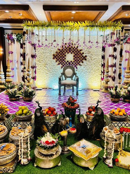 An elegant stage with a white floral backdrop featuring a gold lattice design.