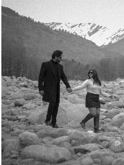 A timeless black and white shot from a post-wedding session in Manali, capturing a quiet walk across a rocky riverbed.