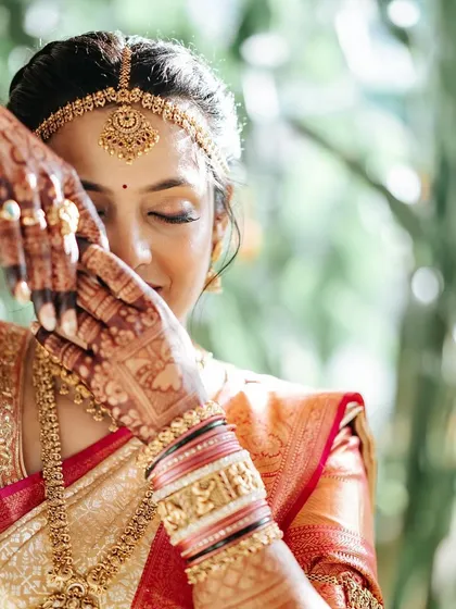 A close-up of the South Indian bride, showcasing her intricate henna and traditional jewelry.