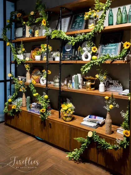 A shelving unit decorated with garlands of greenery and sunflowers, brightening up a corner of the venue.