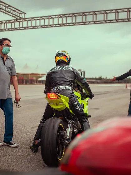 A rider in a custom leather jacket sits on his powerful superbike, ready for action.