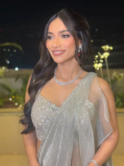 The soft waves perfectly complement the client's delicate features and sparkling attire.