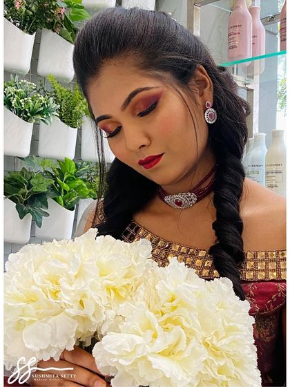 This model looks so serene. The warm, reddish tones on her eyes and the matching lip color create a cohesive and striking look, perfect for any festive celebration.