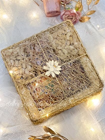 This is my square mesh box hamper for Diwali, all closed up. The golden wire mesh and simple flower detail give it a rustic yet elegant feel.