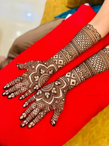 This design features beautiful mandalas on the palms with detailed patterns extending up the arms, perfect for a classic bridal look.