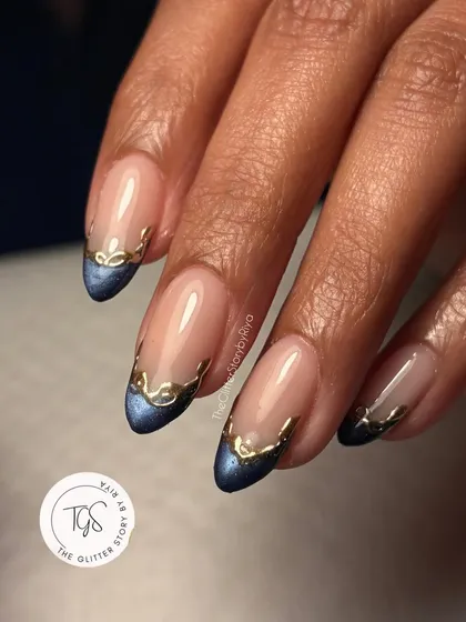 A modern twist on the classic French manicure. This design uses a deep blue cat-eye polish for the tips, accented with a delicate, hand-painted gold chrome border for a touch of refined glamour.