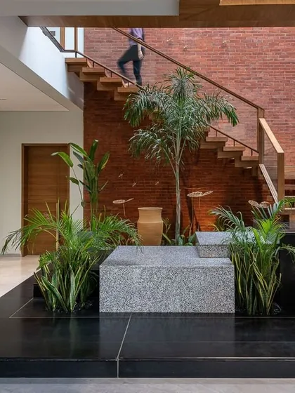I love incorporating natural elements indoors. This indoor planter with an exposed brick accent wall brings life and texture to the base of the staircase, creating a small courtyard feel.