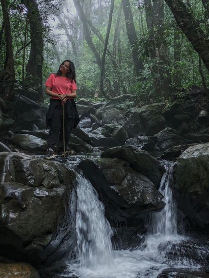 A beautiful shot of a trekker by a small waterfall on the Netravathi trail.