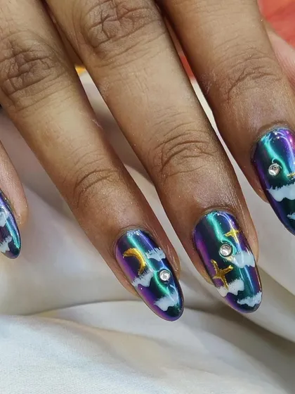 A mystical night sky design with a multi-chrome base, white clouds, and gold celestial charms.