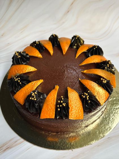 Our Drunken Zesty Belgian Chocolate cake, decorated with candied orange slices and rich chocolate piping. It's a favorite for a reason!