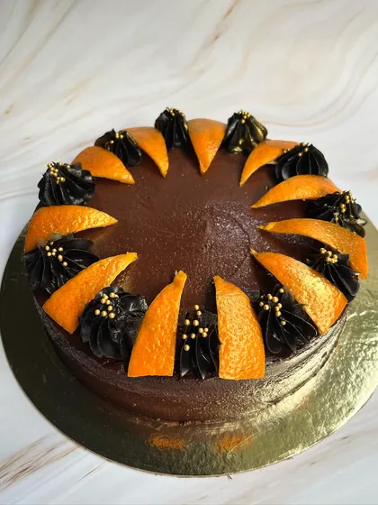 The beautiful contrast of dark chocolate frosting and bright orange slices makes this Drunken Zesty Belgian Chocolate cake a visual treat.