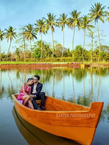 A wide shot showing the couple in a boat on a picturesque lake, capturing the tranquility and beauty of the location for their pre-wedding photos.
