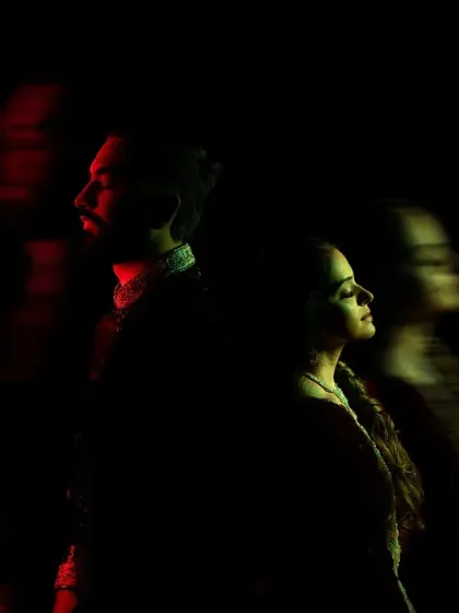 An experimental portrait using slow shutter speed to create a motion blur effect. The red light adds a touch of drama and passion.