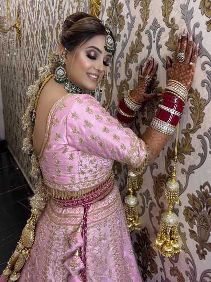 A playful and happy pose from the bride. This shot captures her joy and the beautiful movement of her lehenga and hairstyle.