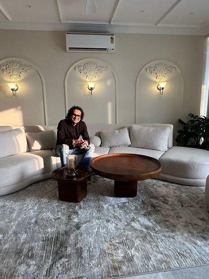 Taking a moment to enjoy the finished living room. The curved sofa and arched wall details create a space that is both elegant and comfortable.