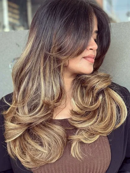 A perfect example of a modern, trendy look. This beautiful blonde balayage is paired with a chic butterfly haircut, creating volume, movement, and a sun-kissed style that’s full of life.