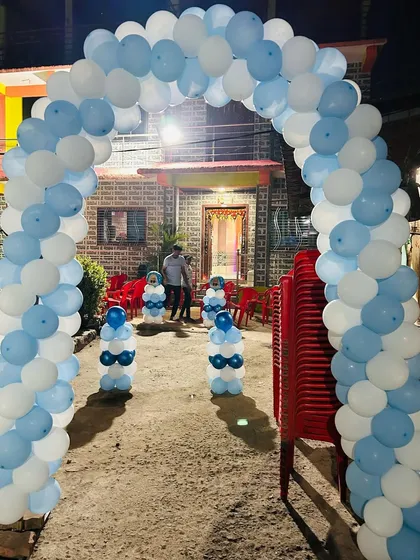 A blue and white balloon arch creating an inviting entrance for a Boss Baby themed birthday party held at a home.