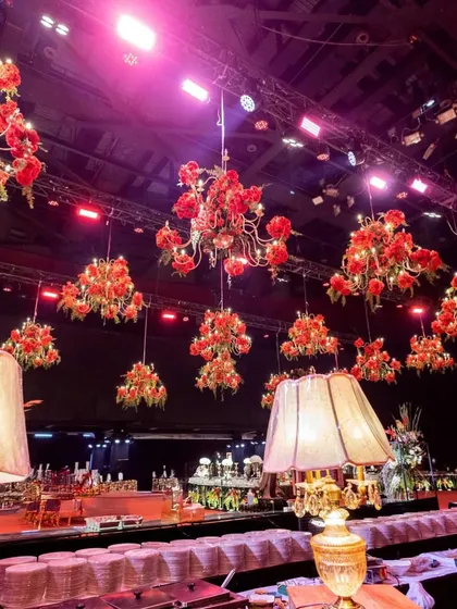 The bar and buffet area featured hanging chandeliers adorned with red roses, complemented by vintage-style table lamps that added a layer of warm, ambient lighting.