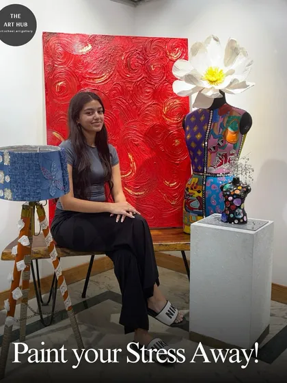 Paint your stress away in my creative sanctuary. This student is pictured with her finished projects, including a vibrant textured painting and a custom-decorated mannequin.